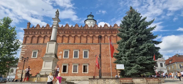 a brick building with a statue and a flag on the side